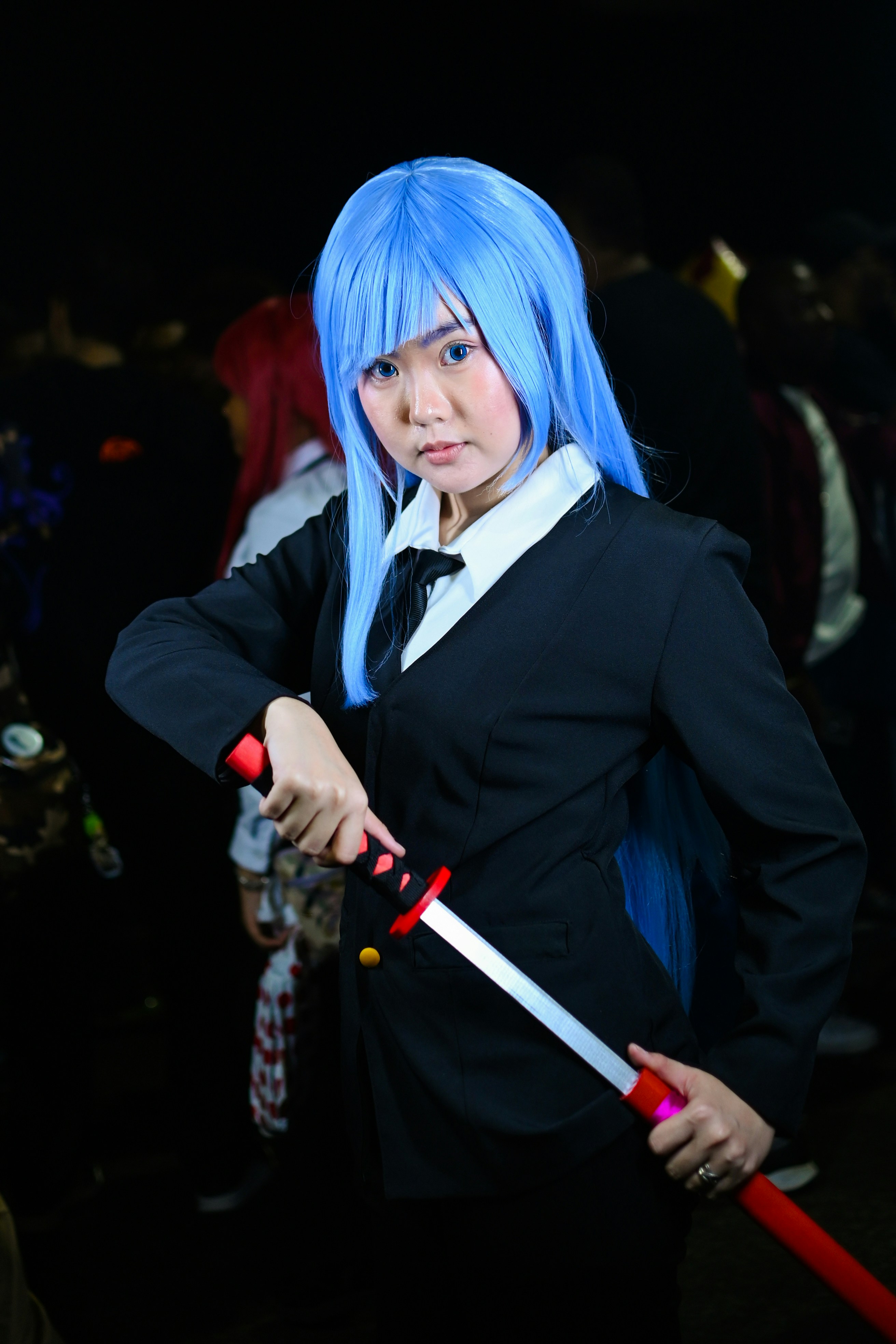 A girl with blue hair is holding a sword