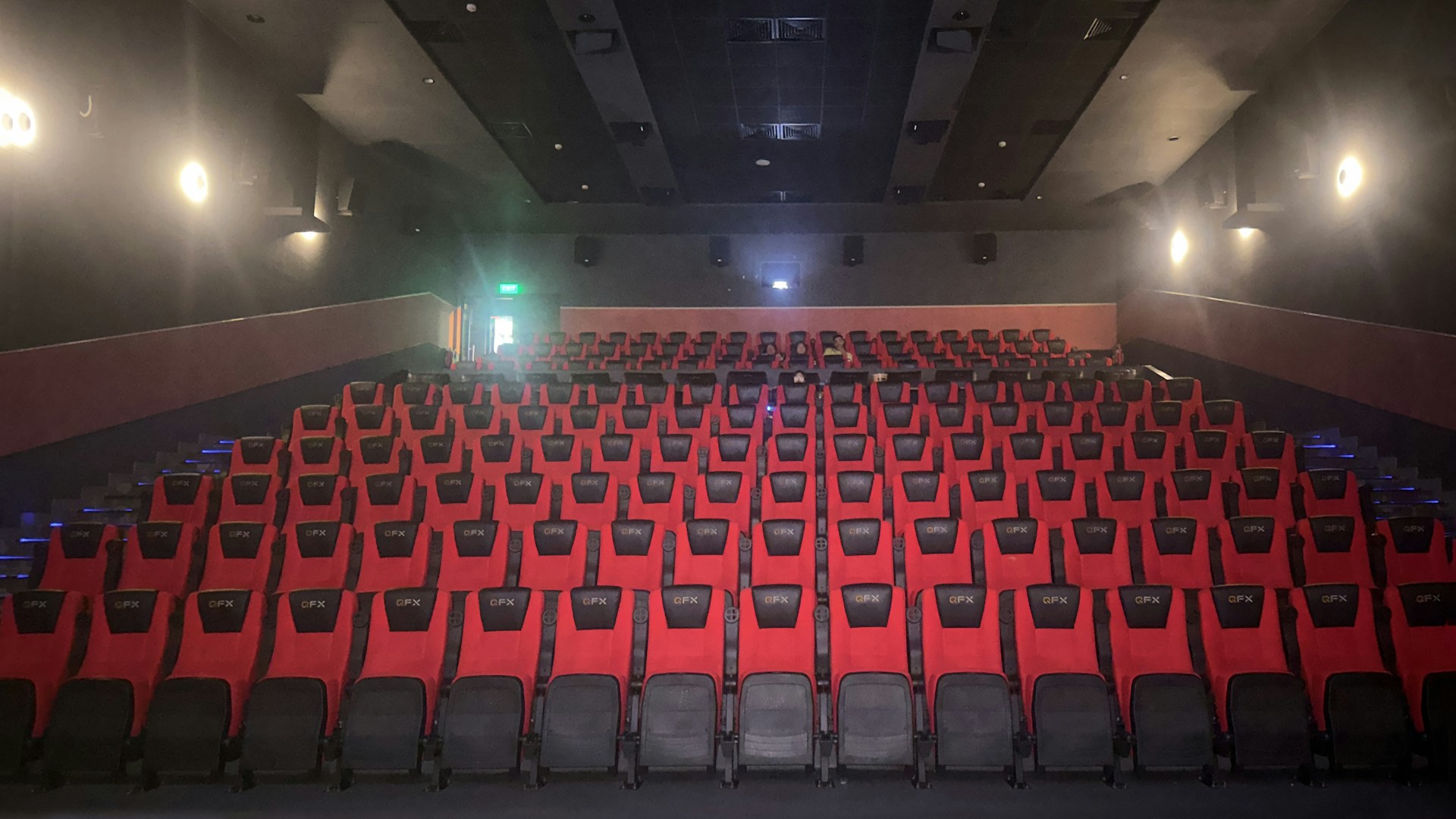 An empty auditorium with rows of red seats