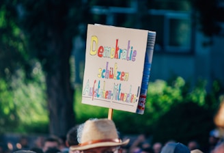 A man with a sign on his head in front of a crowd