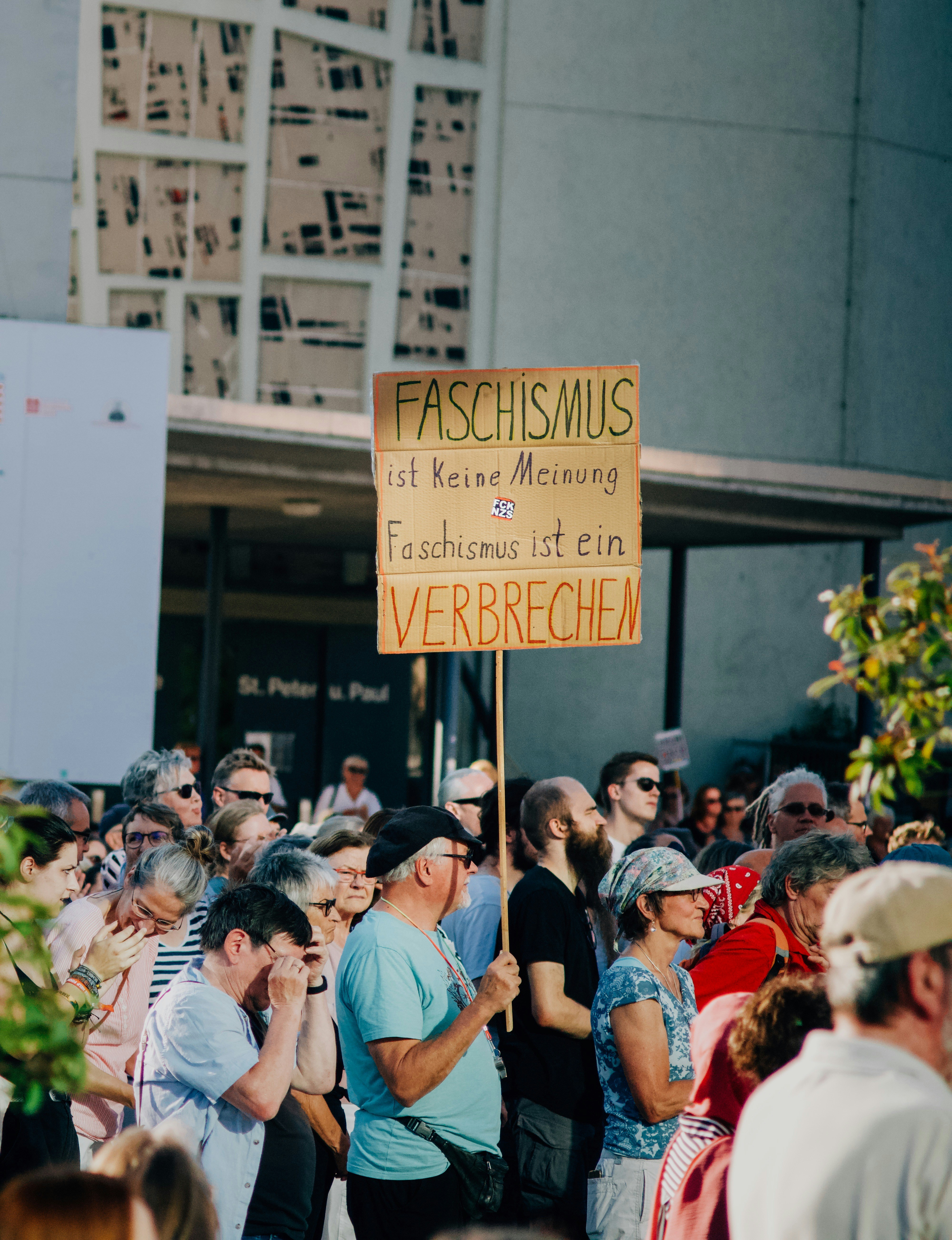 A group of people standing around each other holding a sign photo ...