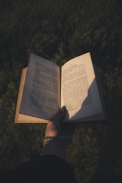 A person holding an open book in their hand