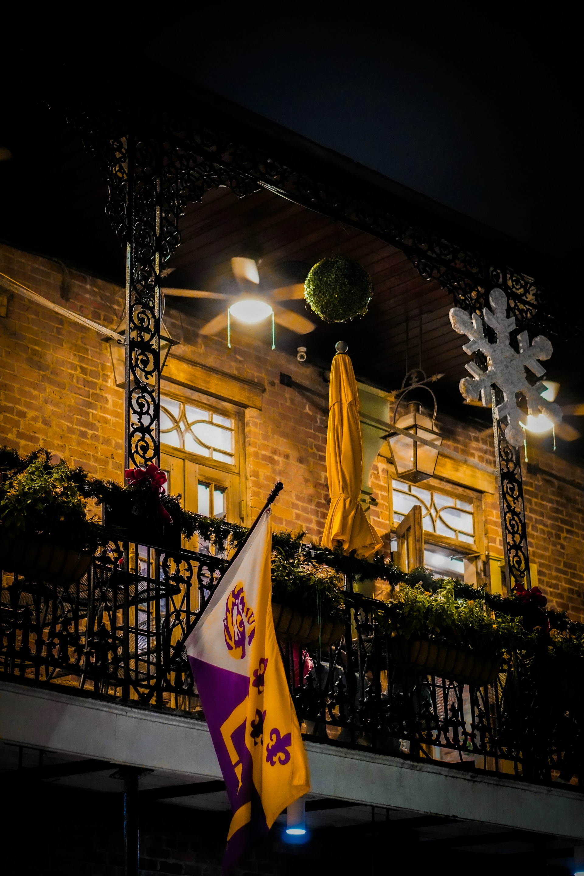 A building with a balcony at night with lights on