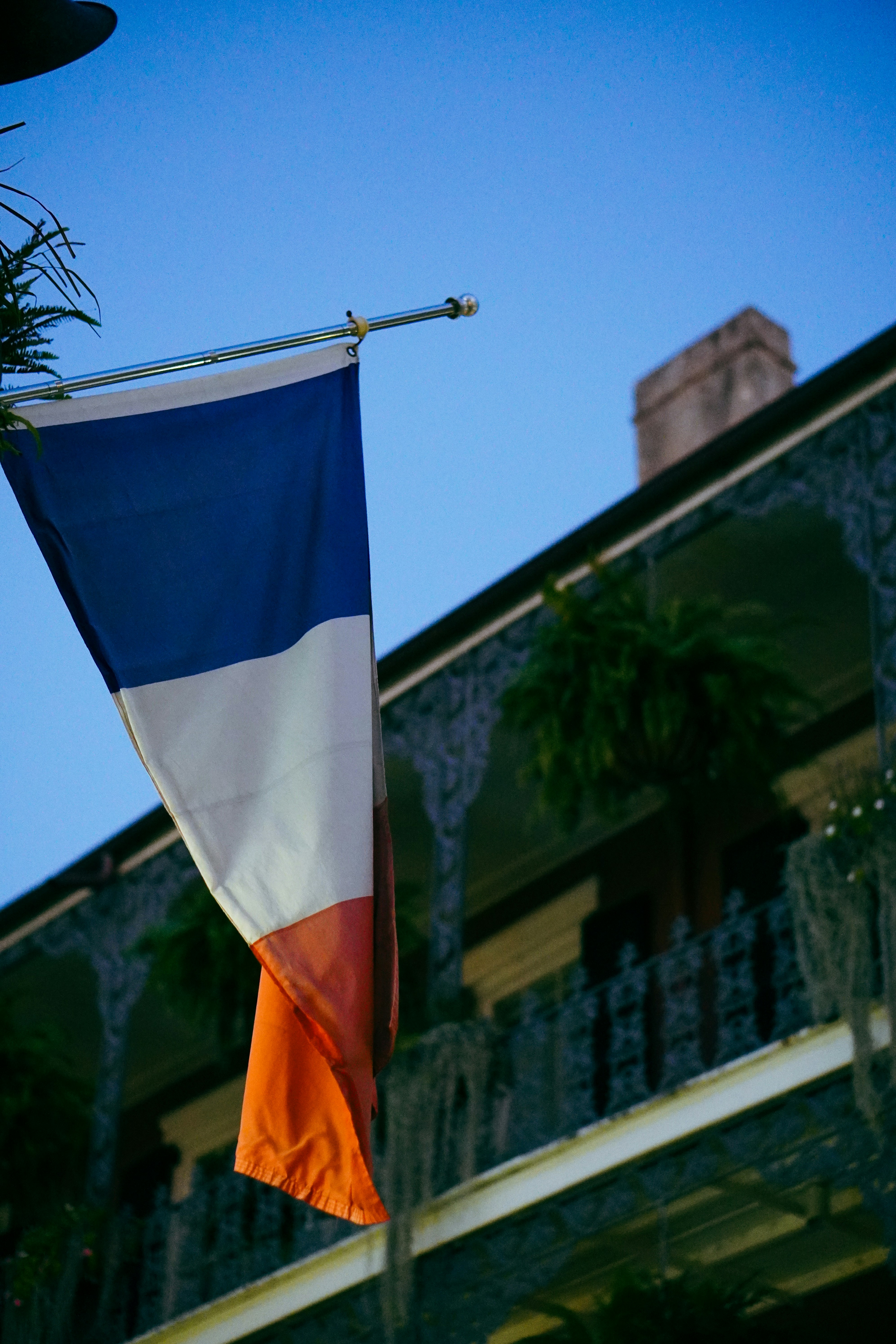 An orange, white and blue flag hanging from a pole