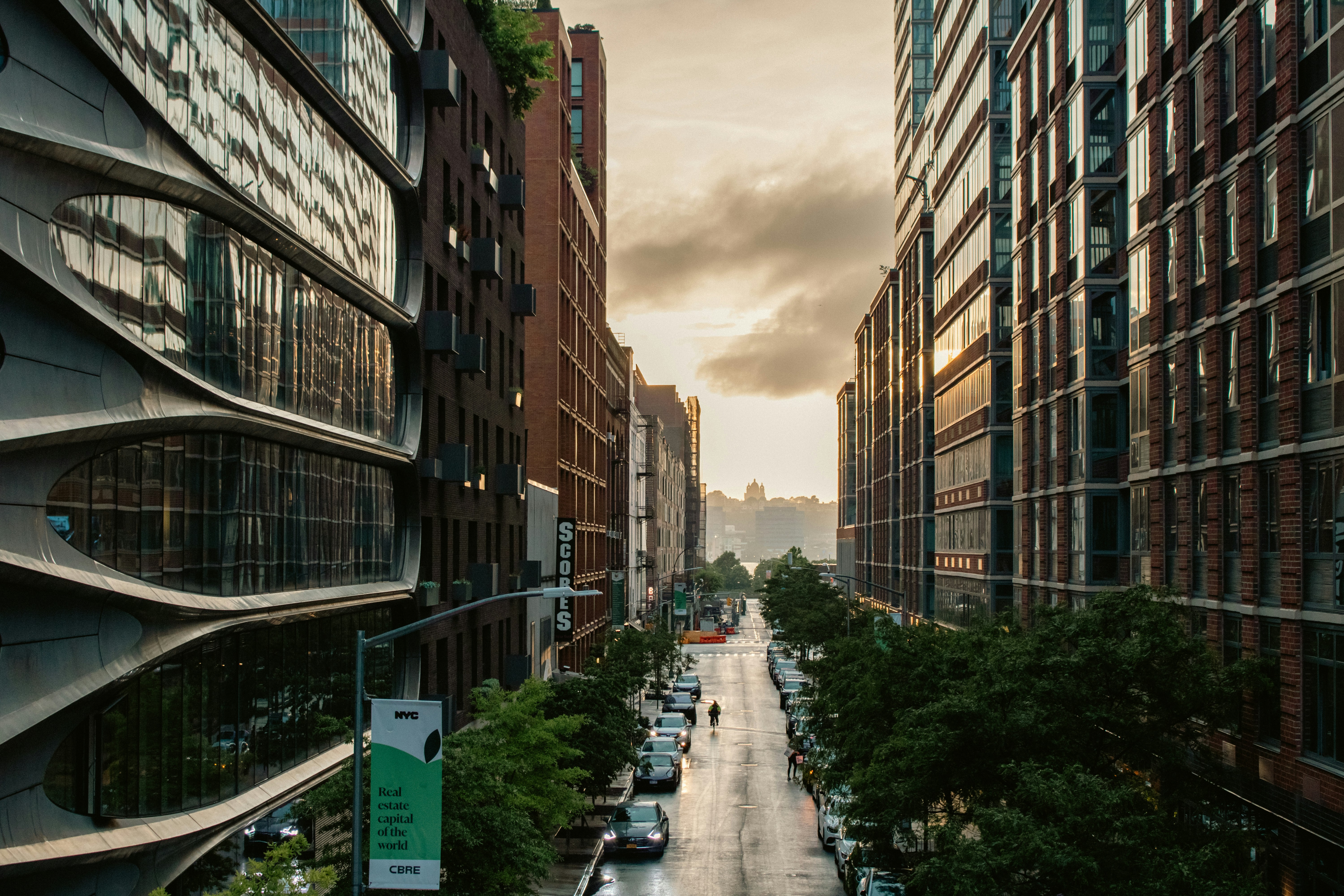 A city street filled with lots of tall buildings, The Chelsea neighborhood photographed from the Highline. It is on the West Side of the borough of Manhattan in New York City. The area
