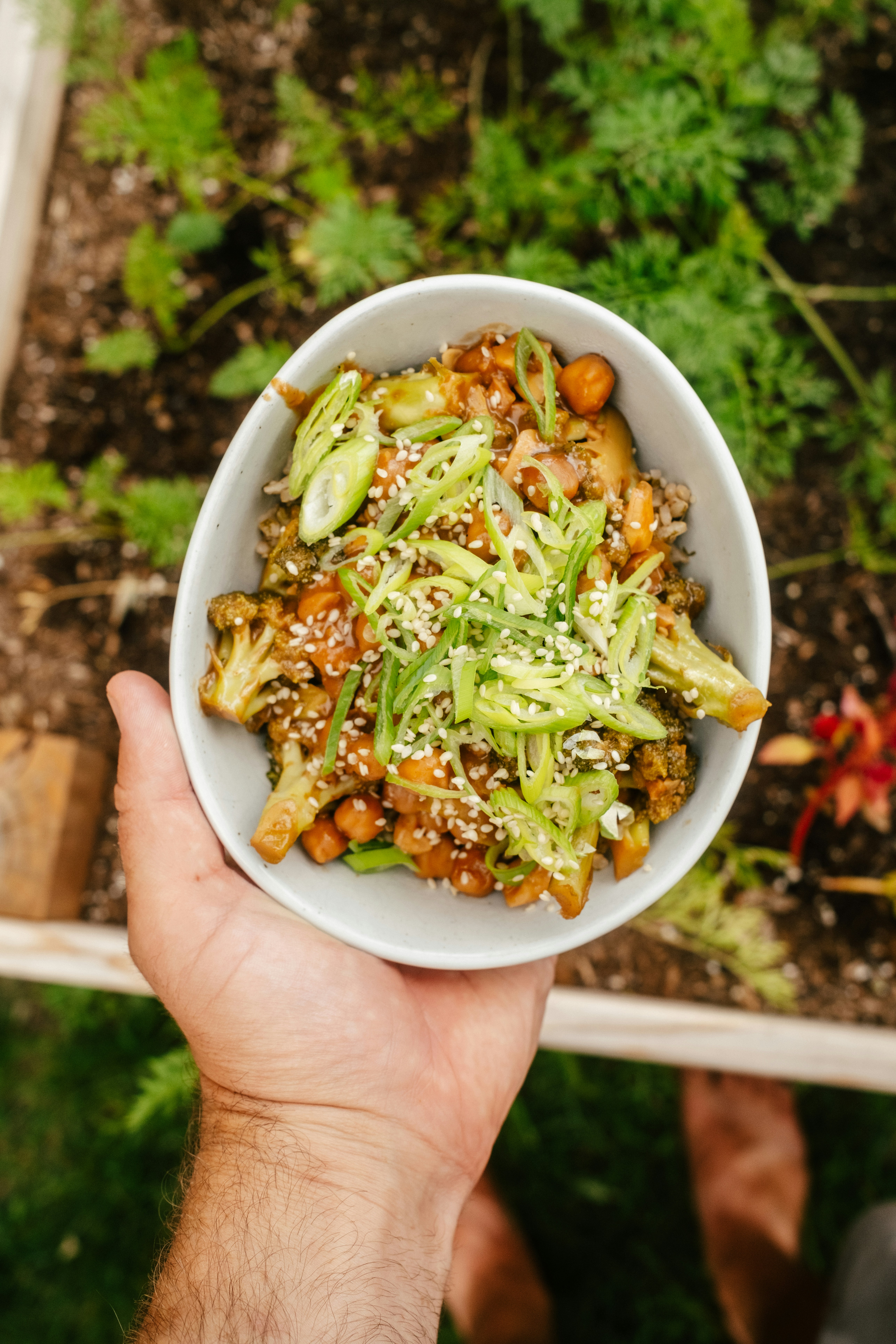 A person holding a bowl of food in their hand