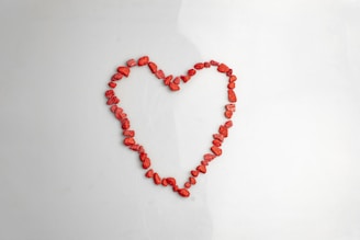 A heart made of red beads on a white background