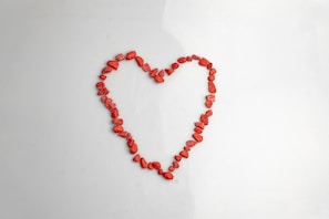 A heart made of red beads on a white background