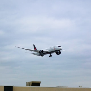 A large jetliner flying through a cloudy sky
