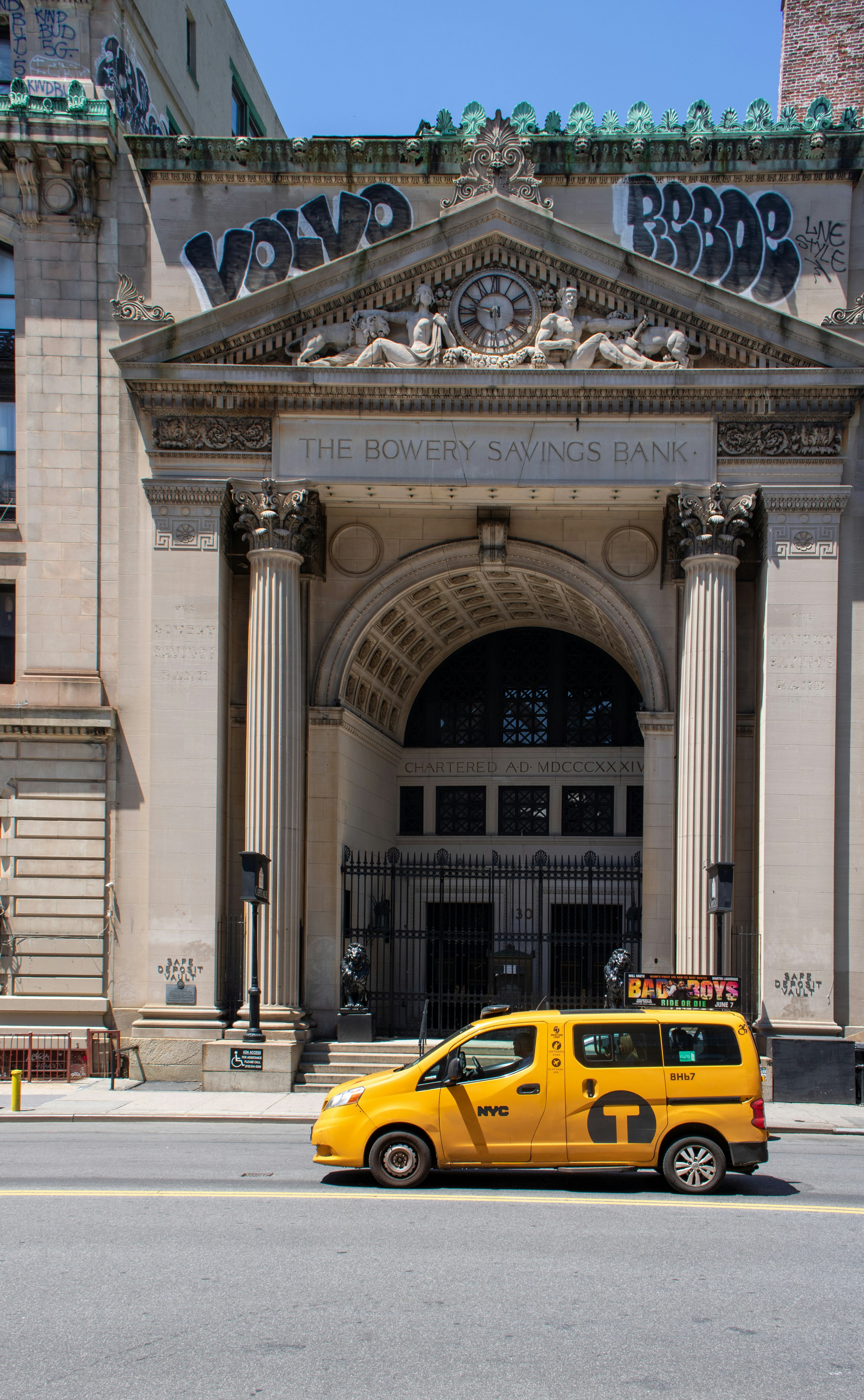 A yellow taxi cab parked in front of a building