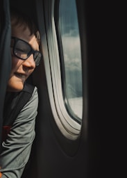 A man looking out the window of an airplane