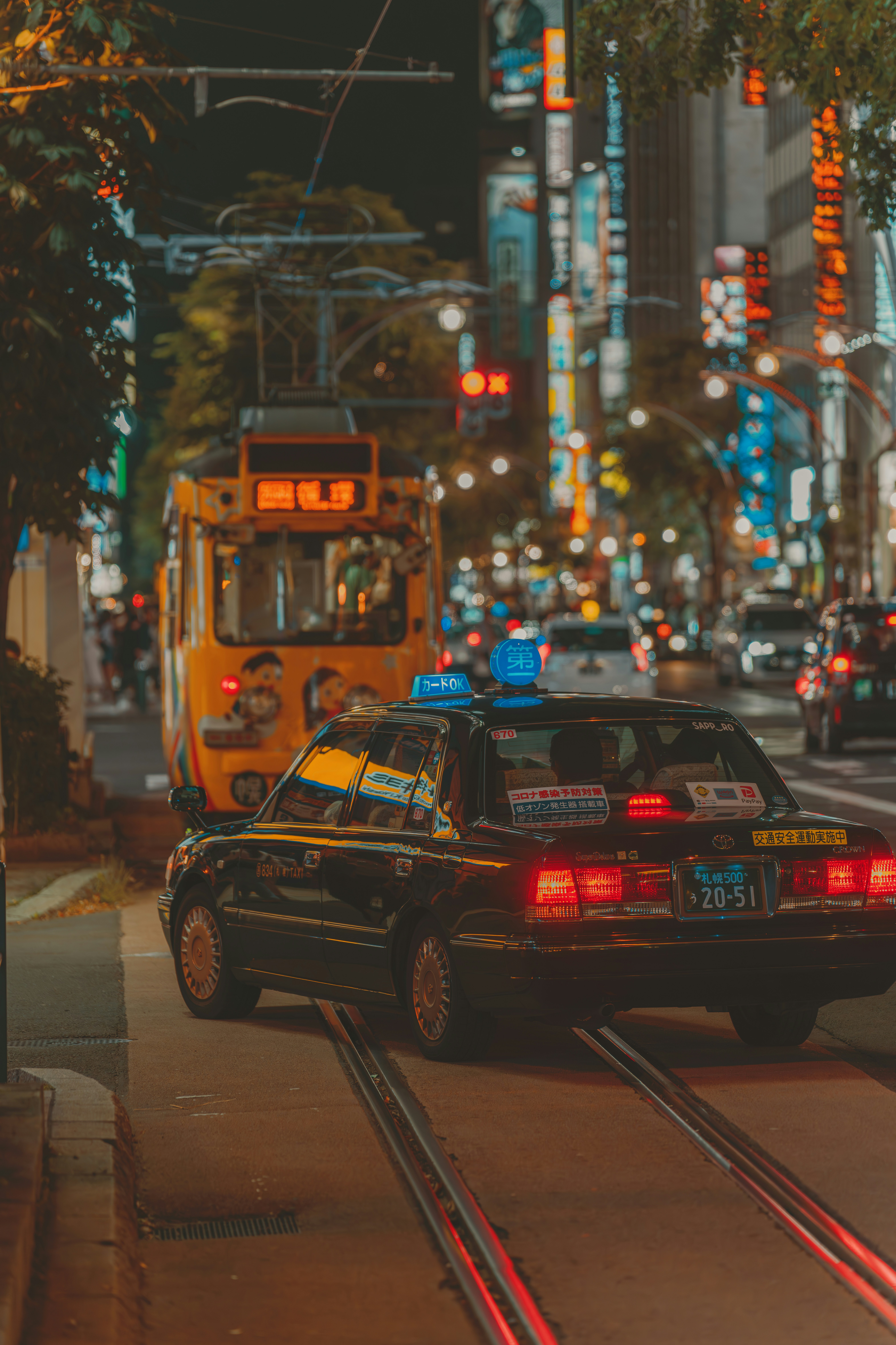 A taxi cab driving down a city street at night