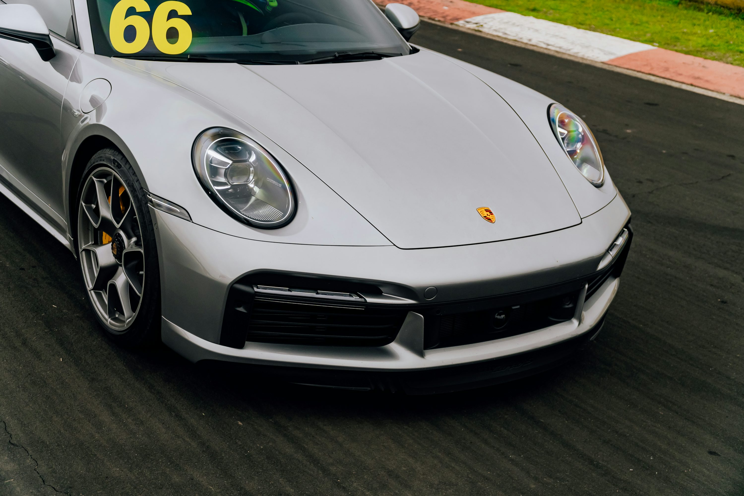 A silver sports car driving down a race track