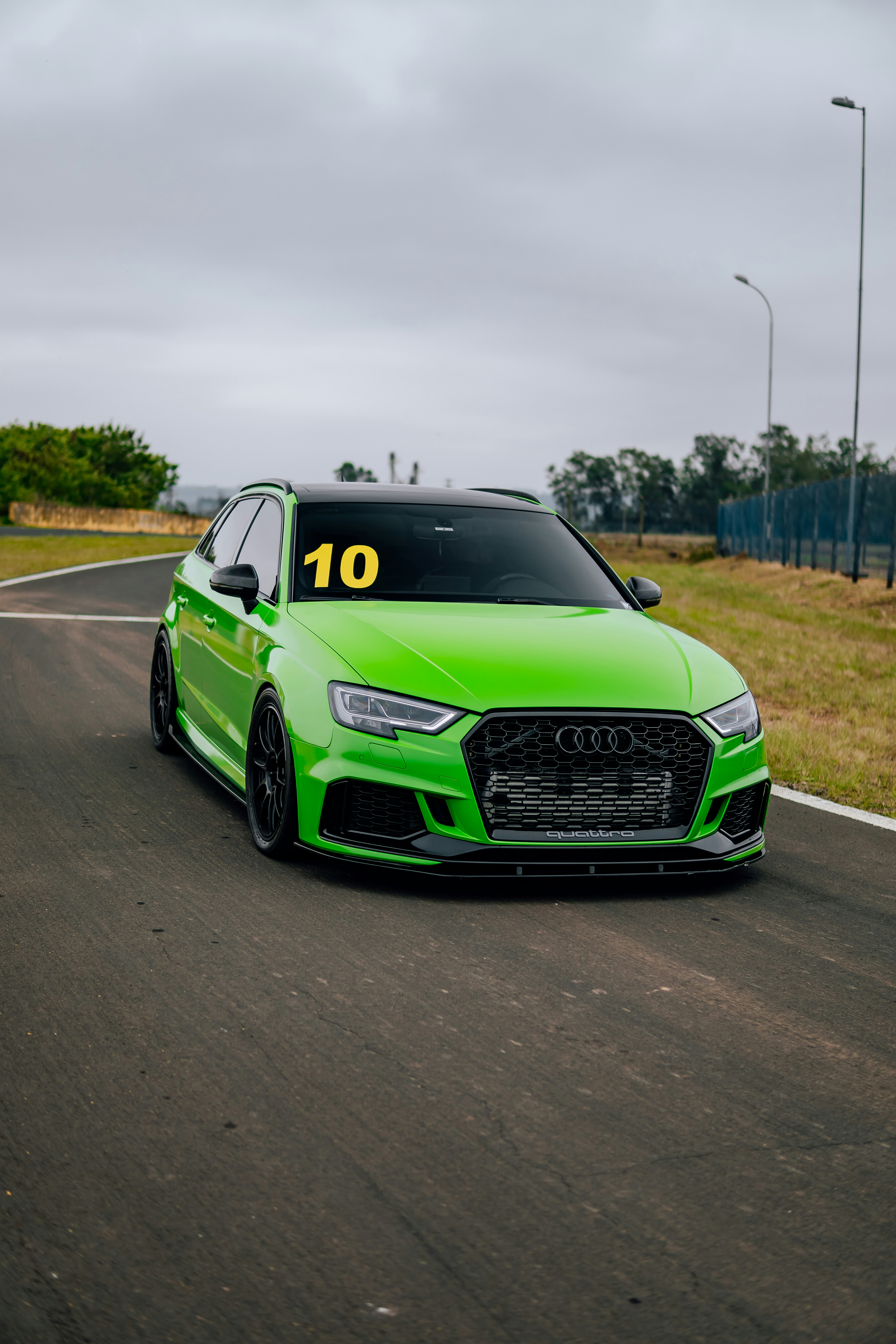 A green car driving down a race track