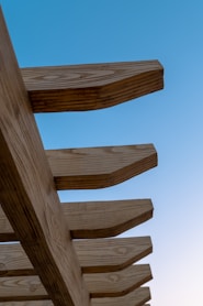 gros plan sur une pergola en bois massif avec ciel bleu en arrière plan