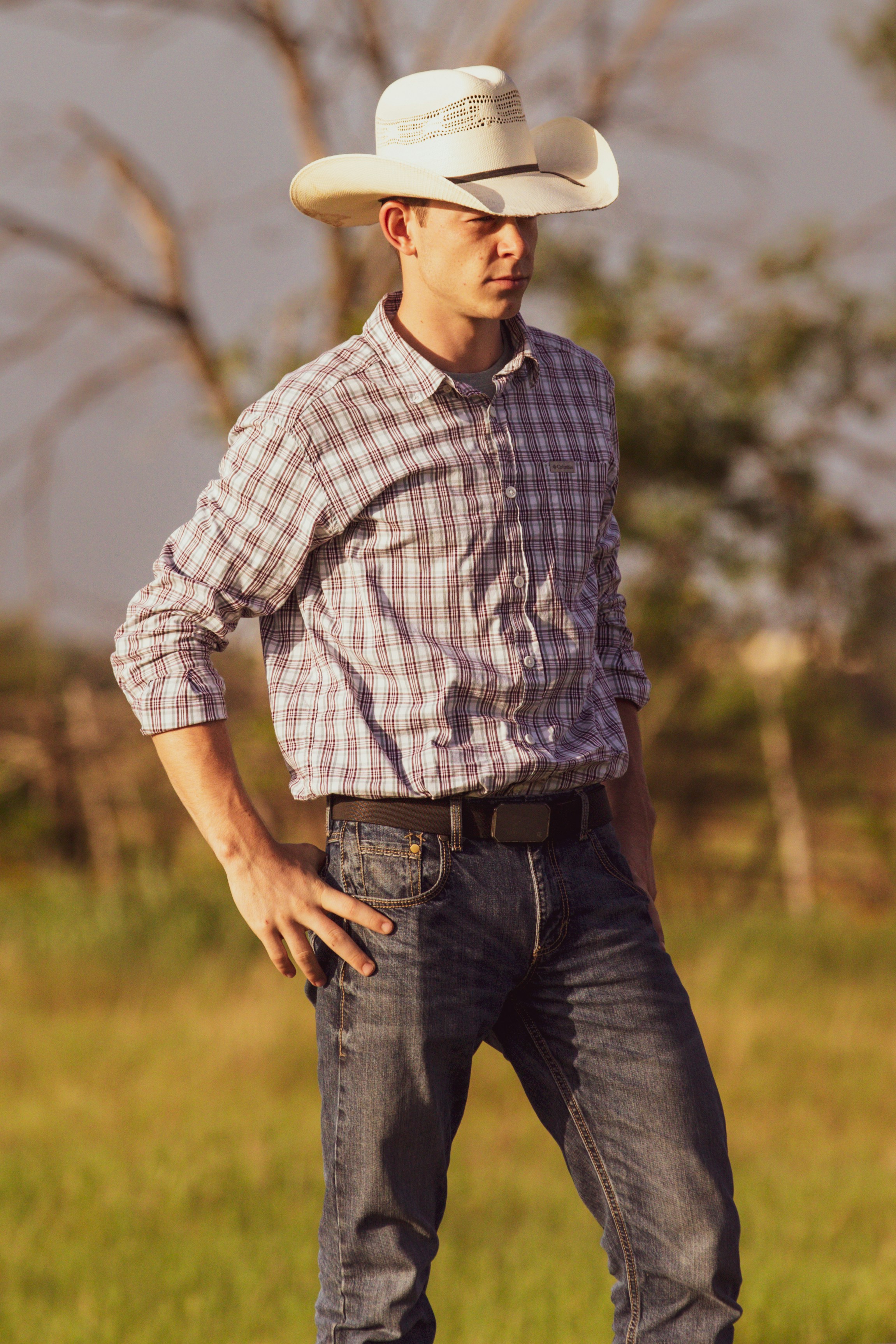A man standing in a field wearing a cowboy hat photo – Free Hat Image ...