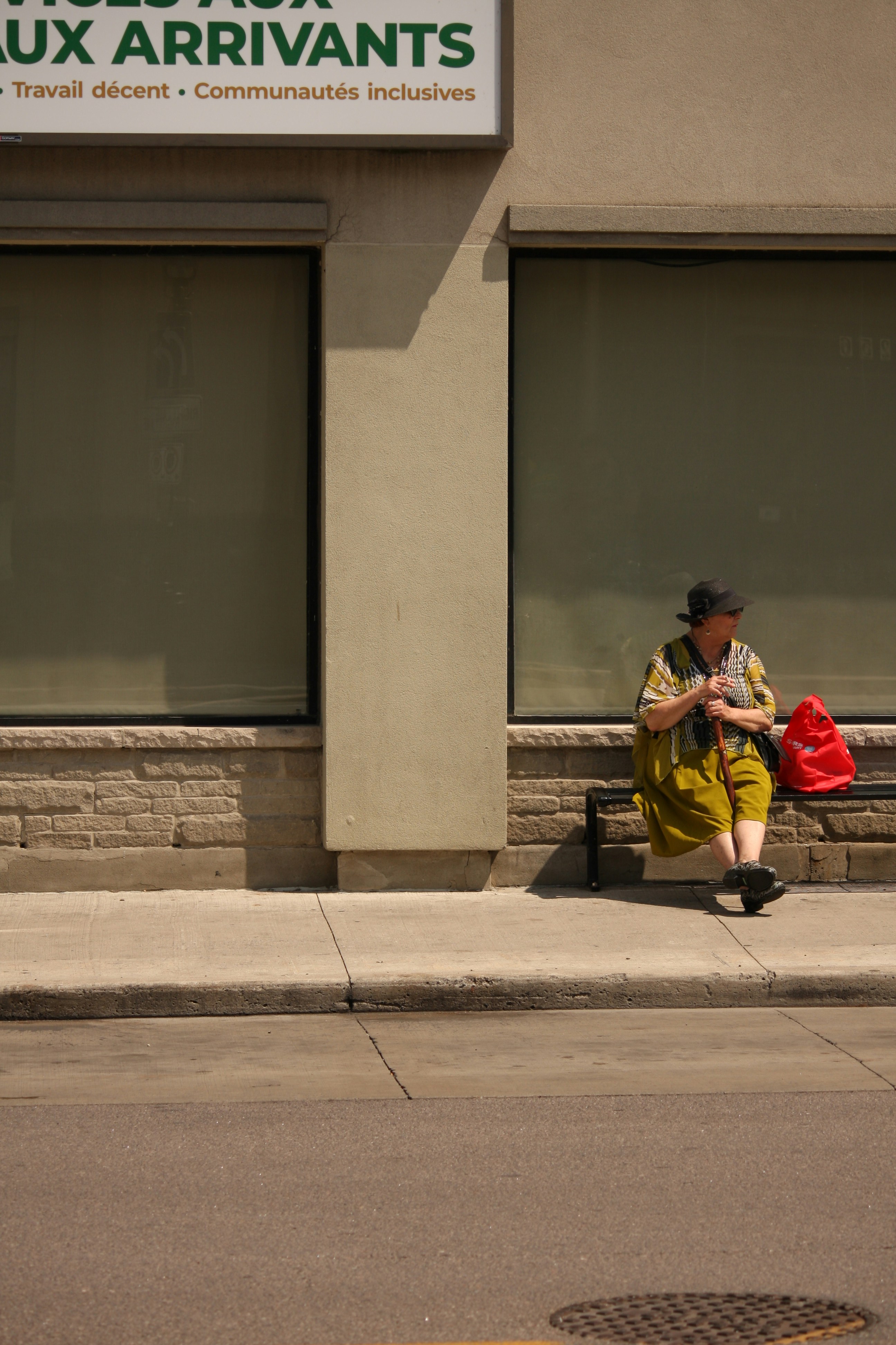 A person sitting on a bench in front of a building
