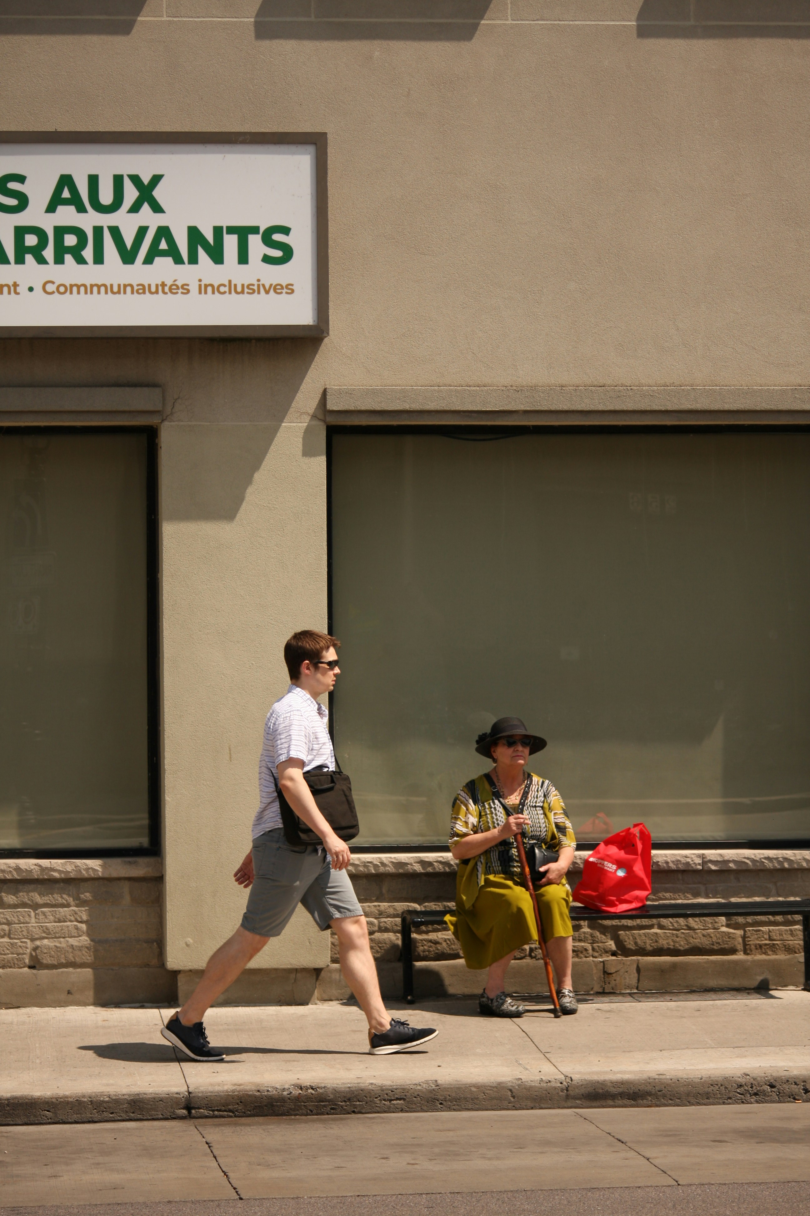 A couple of people walking down a street next to a building