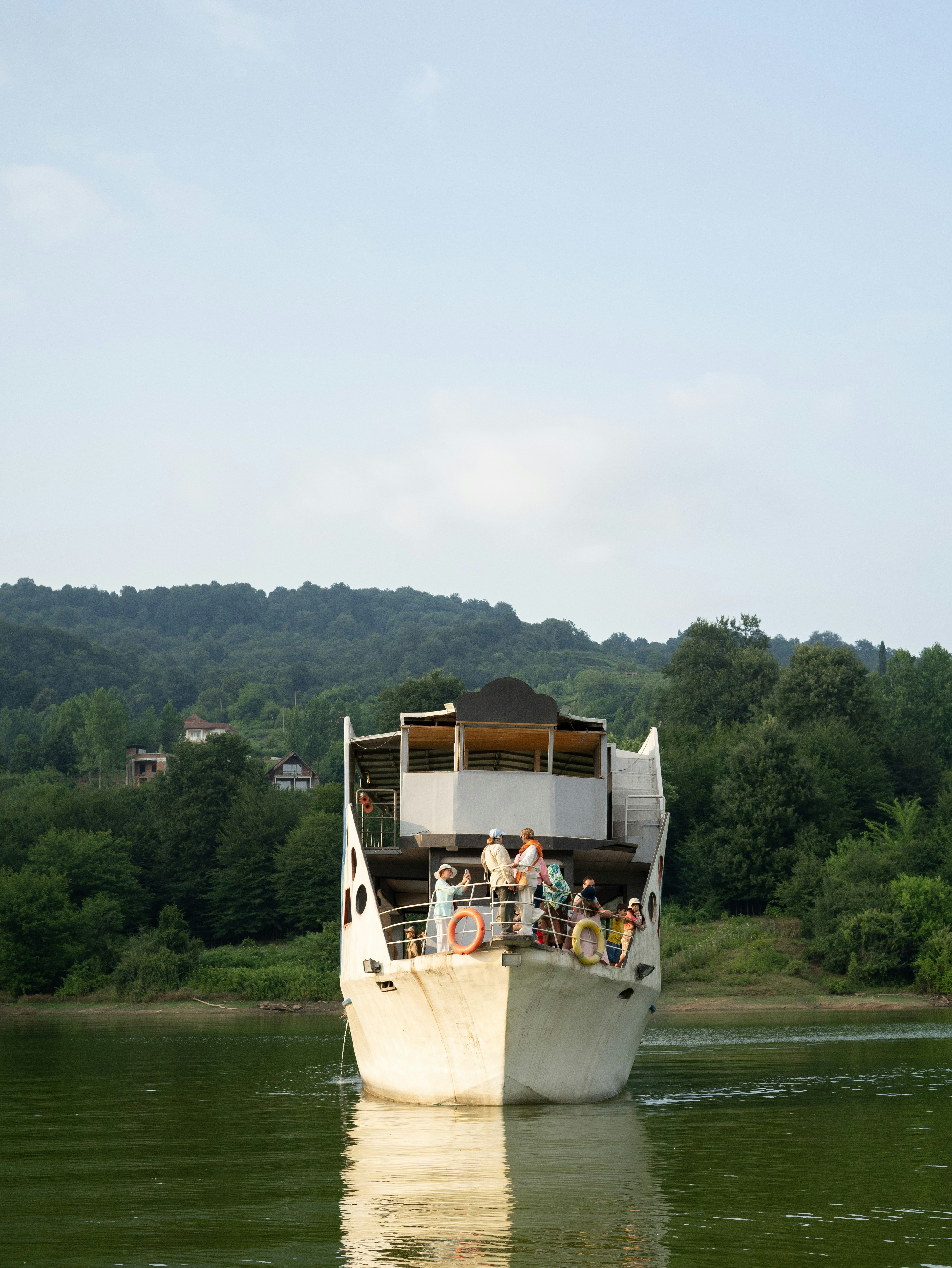 Un gran bote blanco flotando en la cima de un lago