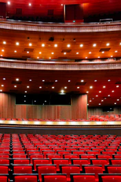 An empty auditorium with red seats and a stage