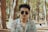 A man wearing sunglasses standing in a forest