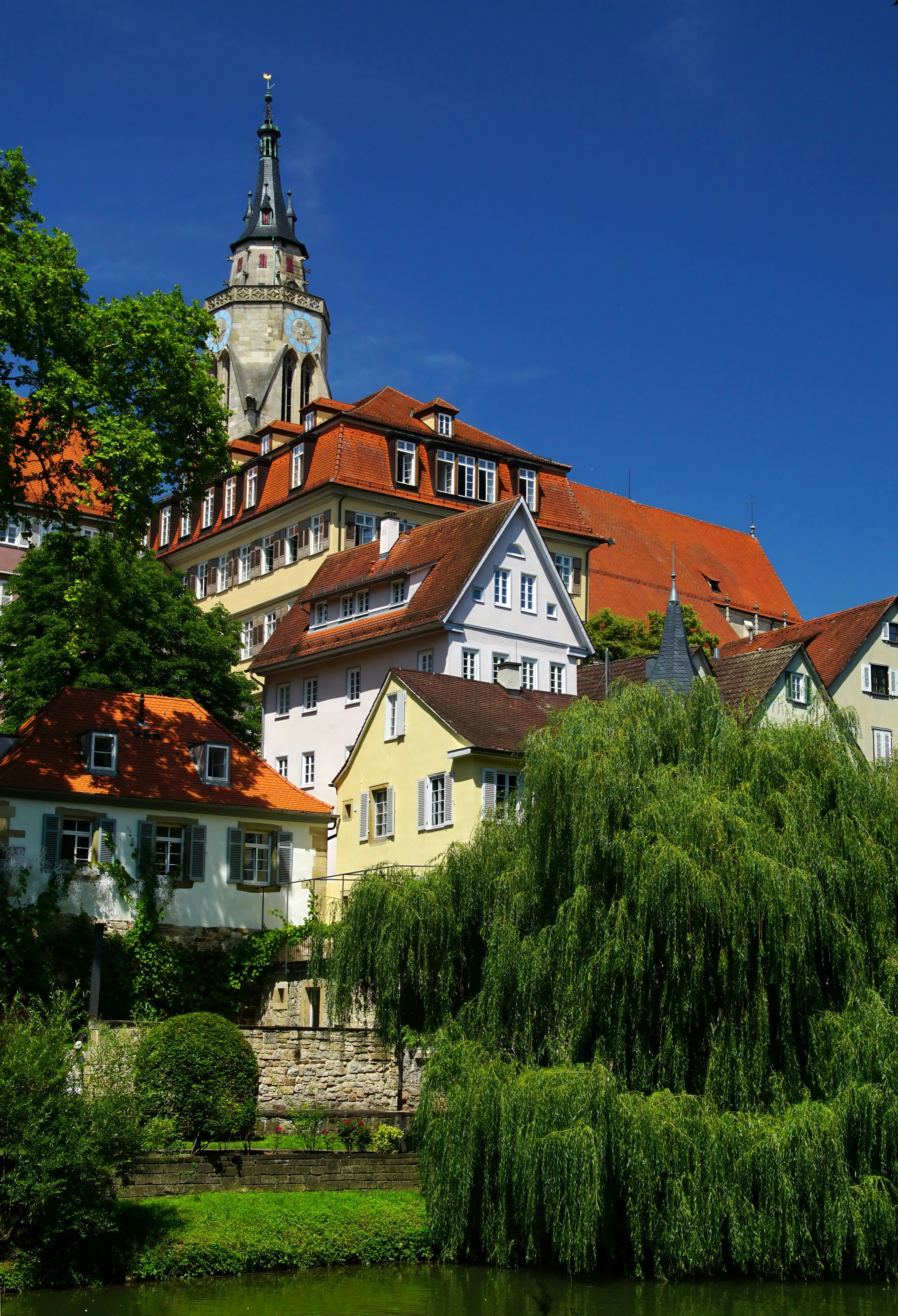A river runs through a small town with a church steeple in the background