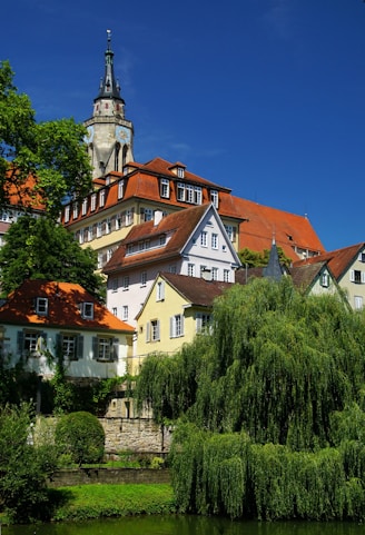 A river runs through a small town with a church steeple in the background