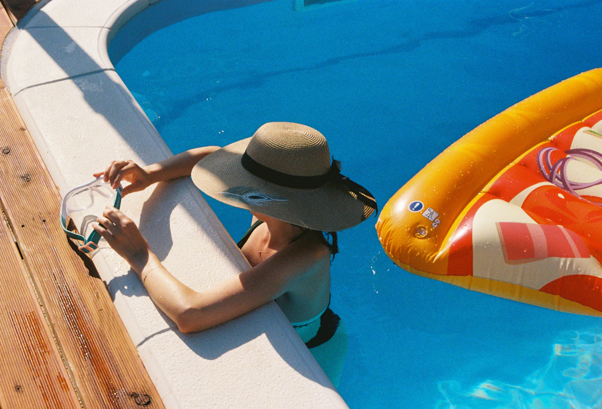 man sitting beside swimming pool