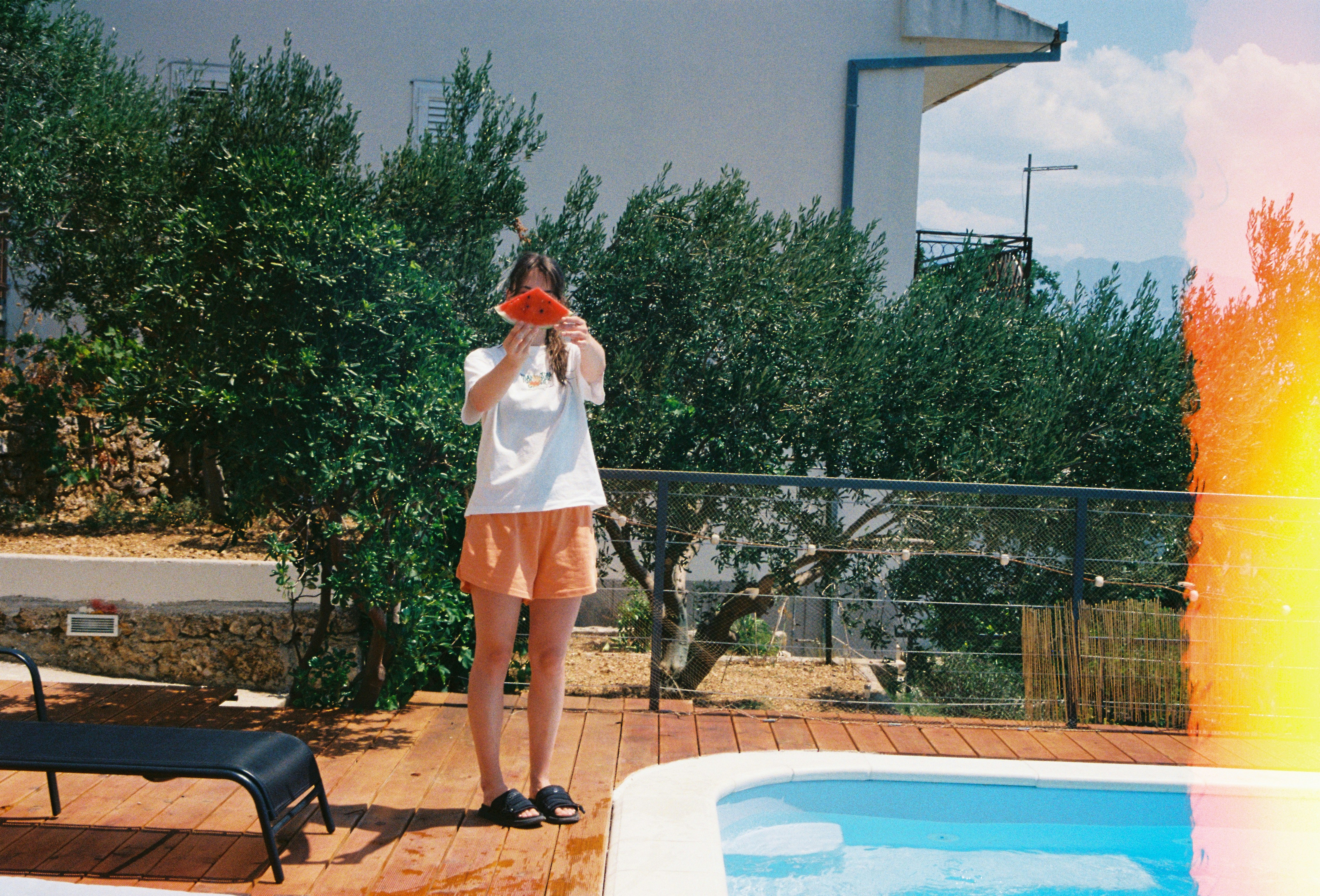 A man standing on a deck next to a swimming pool