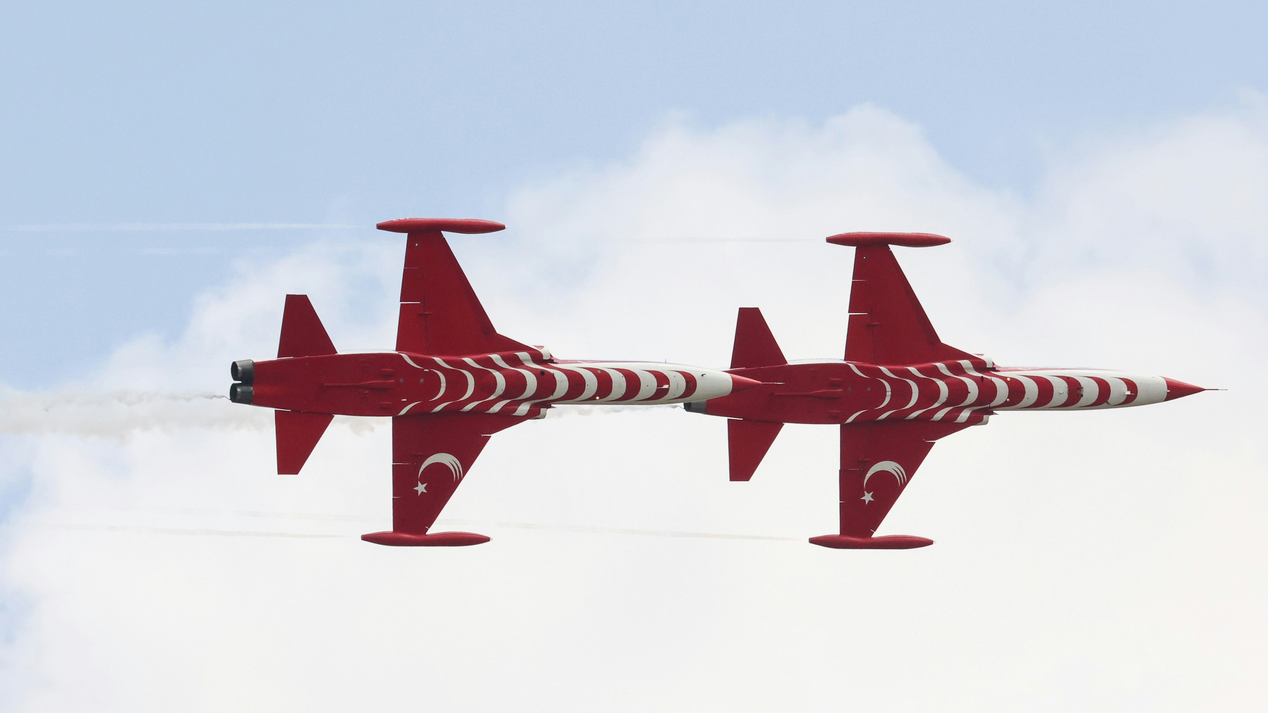 A red and white plane flying in the sky