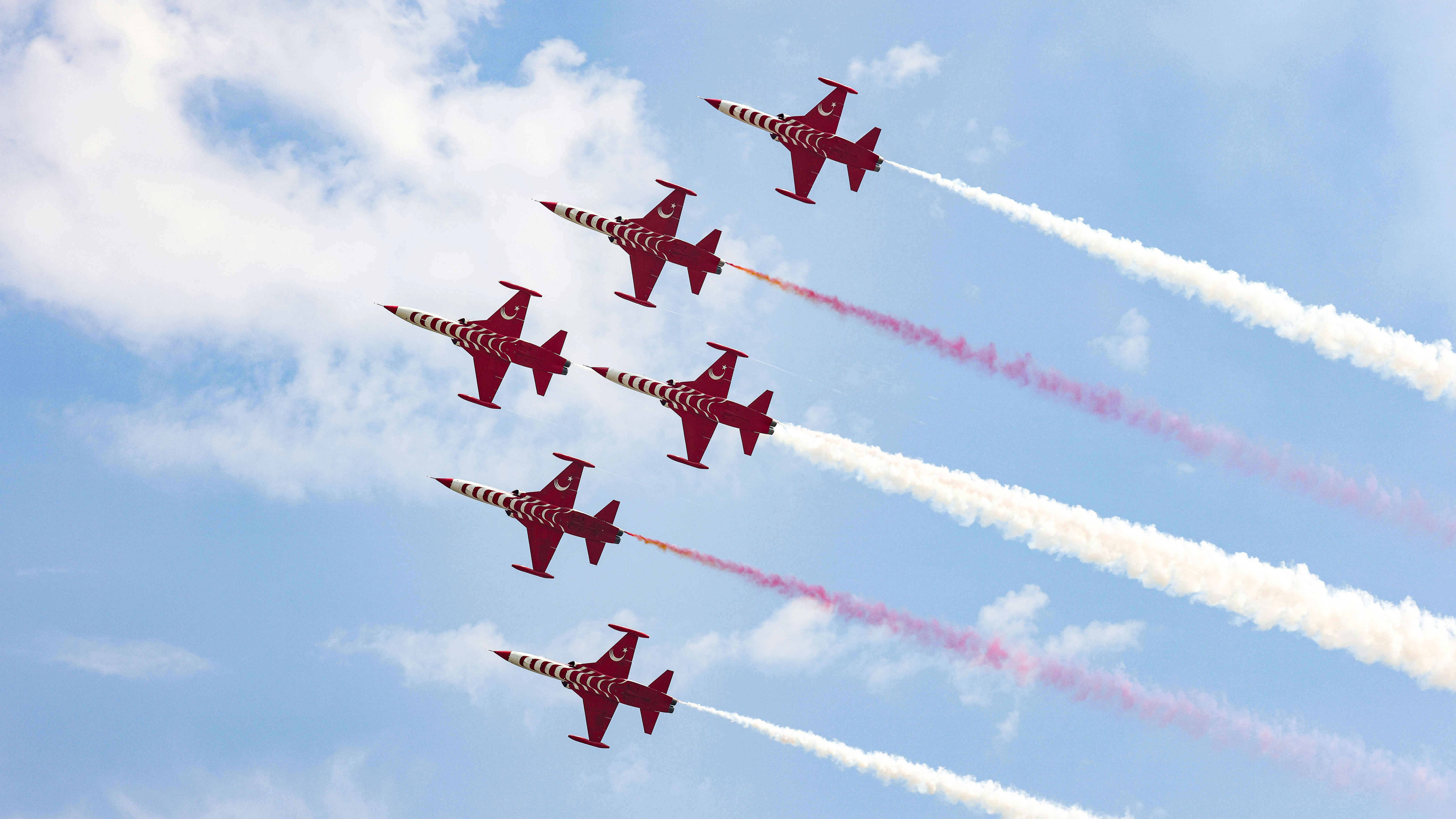 A group of jets flying through a blue sky, A captivating shot of the Turkish Stars, Turkey