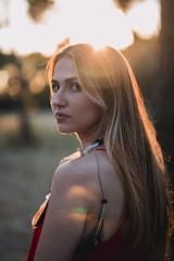 A woman in a red dress standing in front of a tree