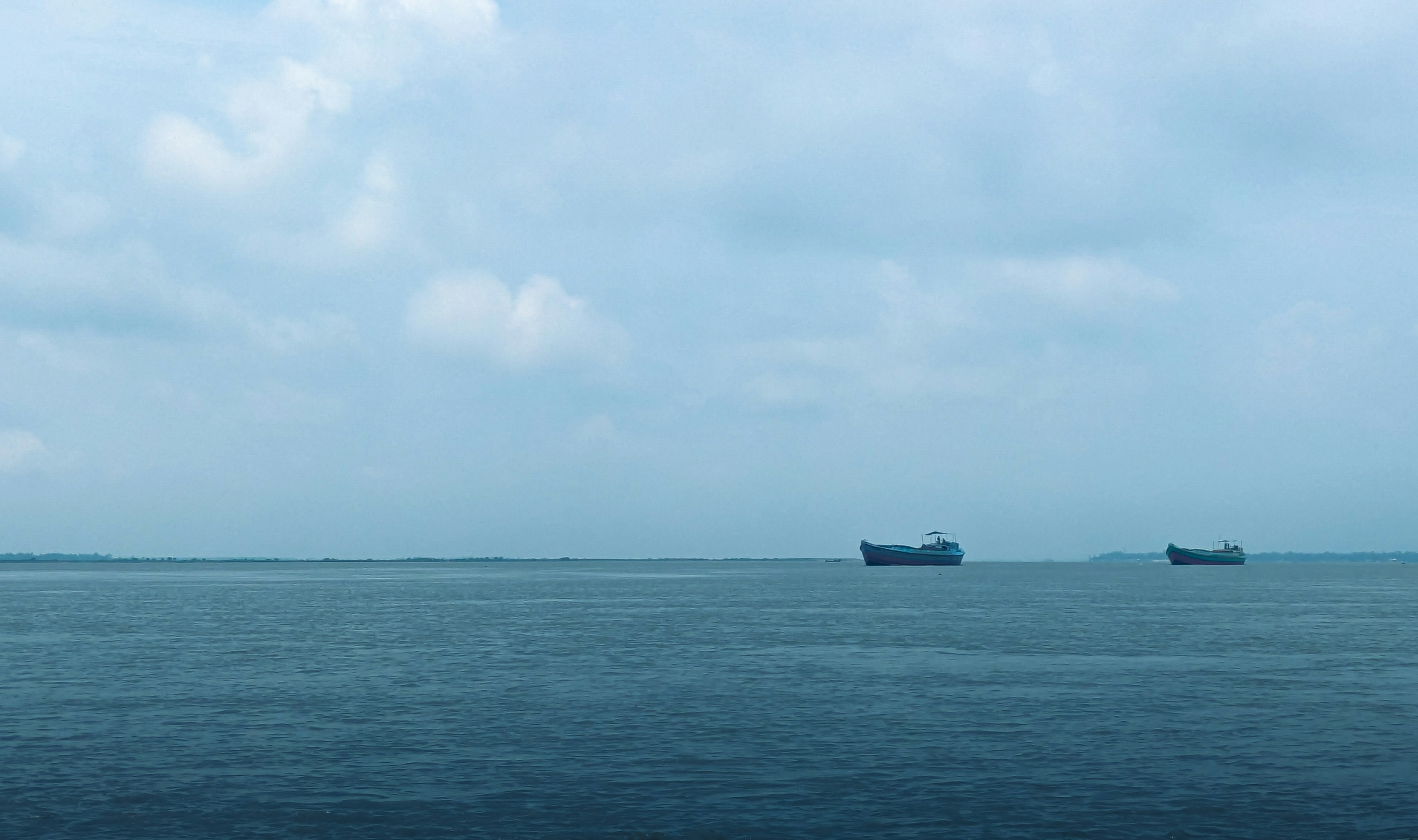 A group of boats floating on top of a large body of water