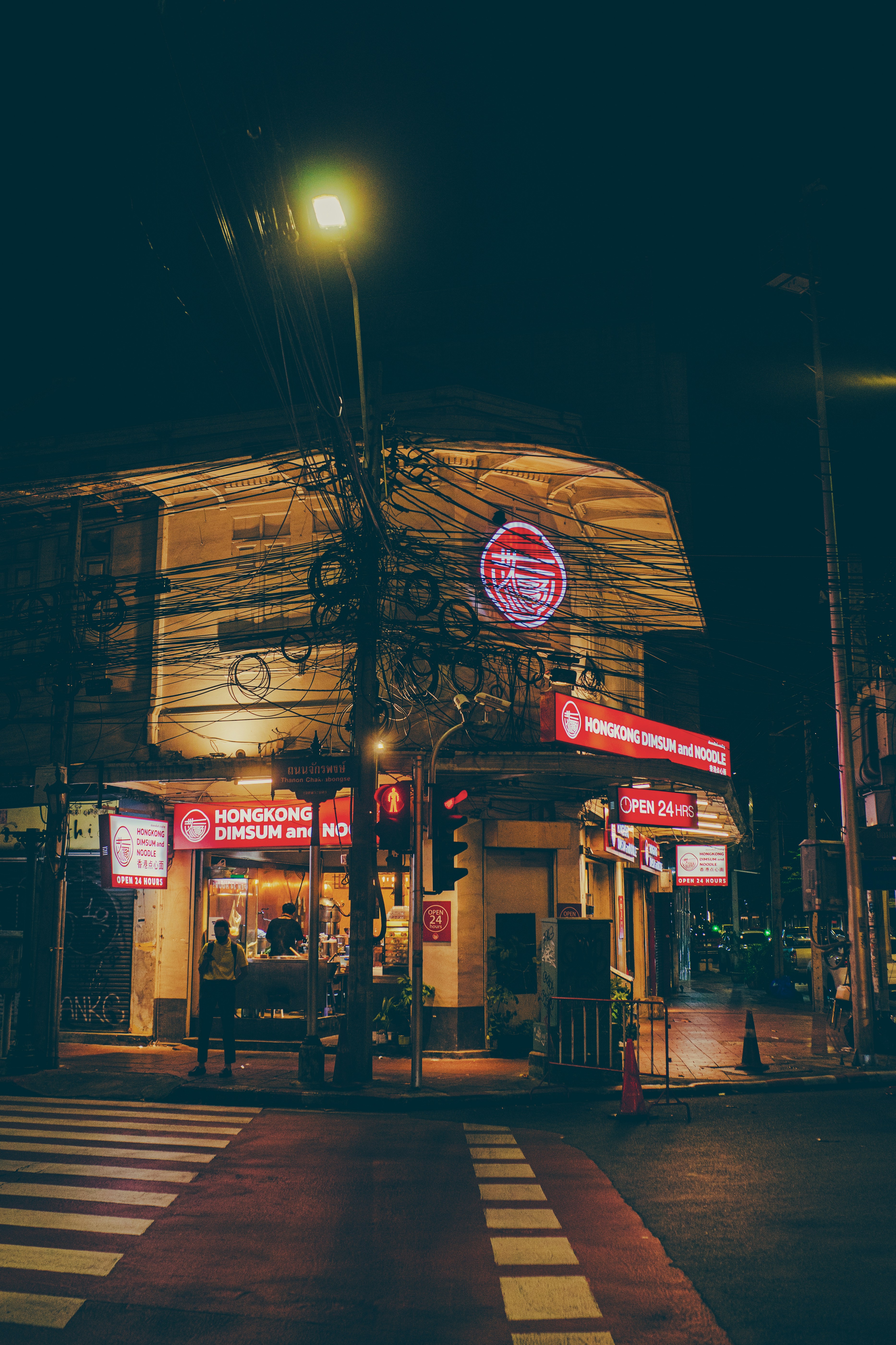 A street corner at night with a building lit up