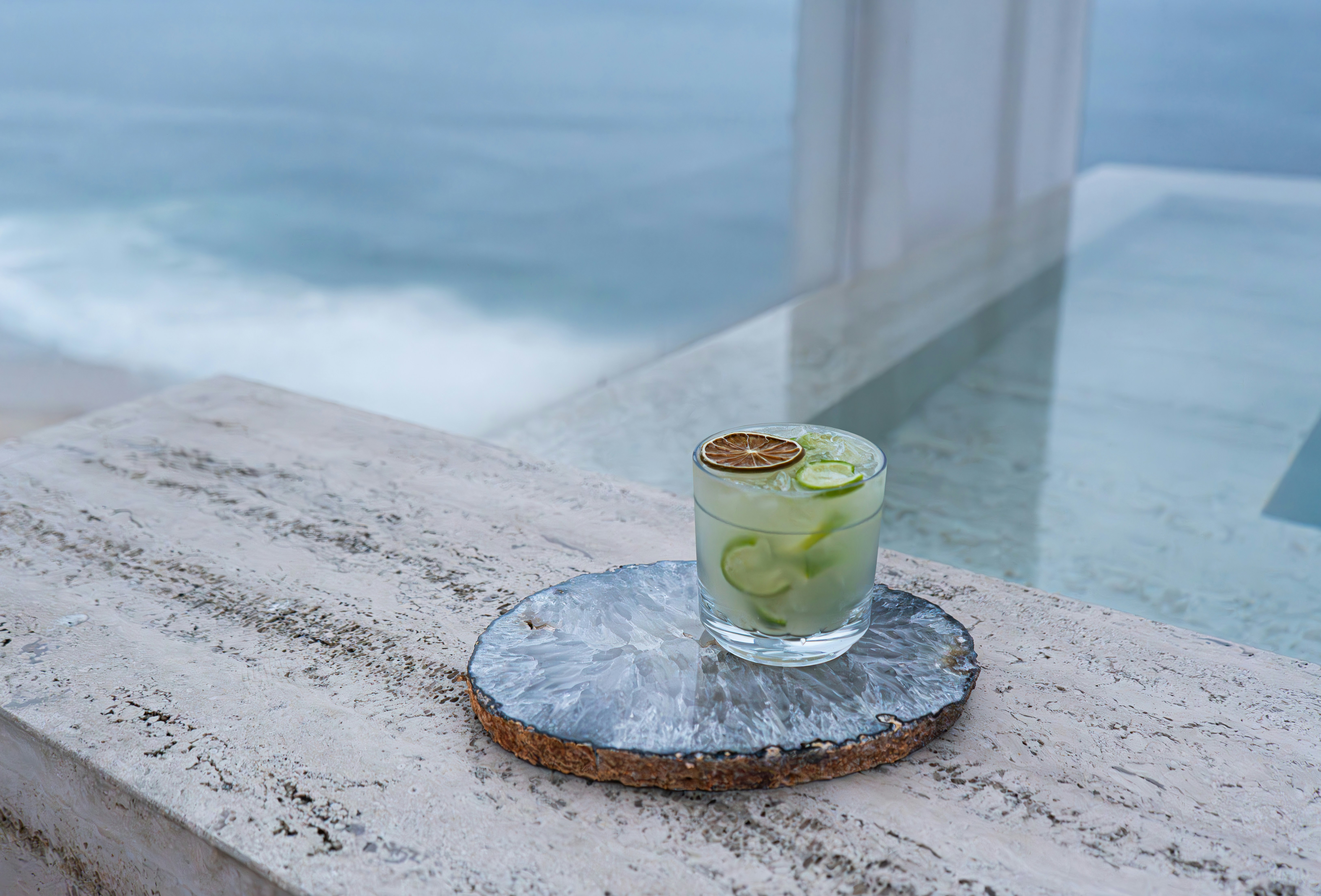 Une boisson posée sur une table au bord de l’océan
