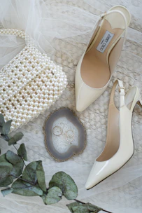 A pair of shoes and a purse on a bed