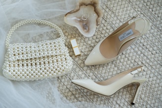 A pair of shoes and a purse on a bed