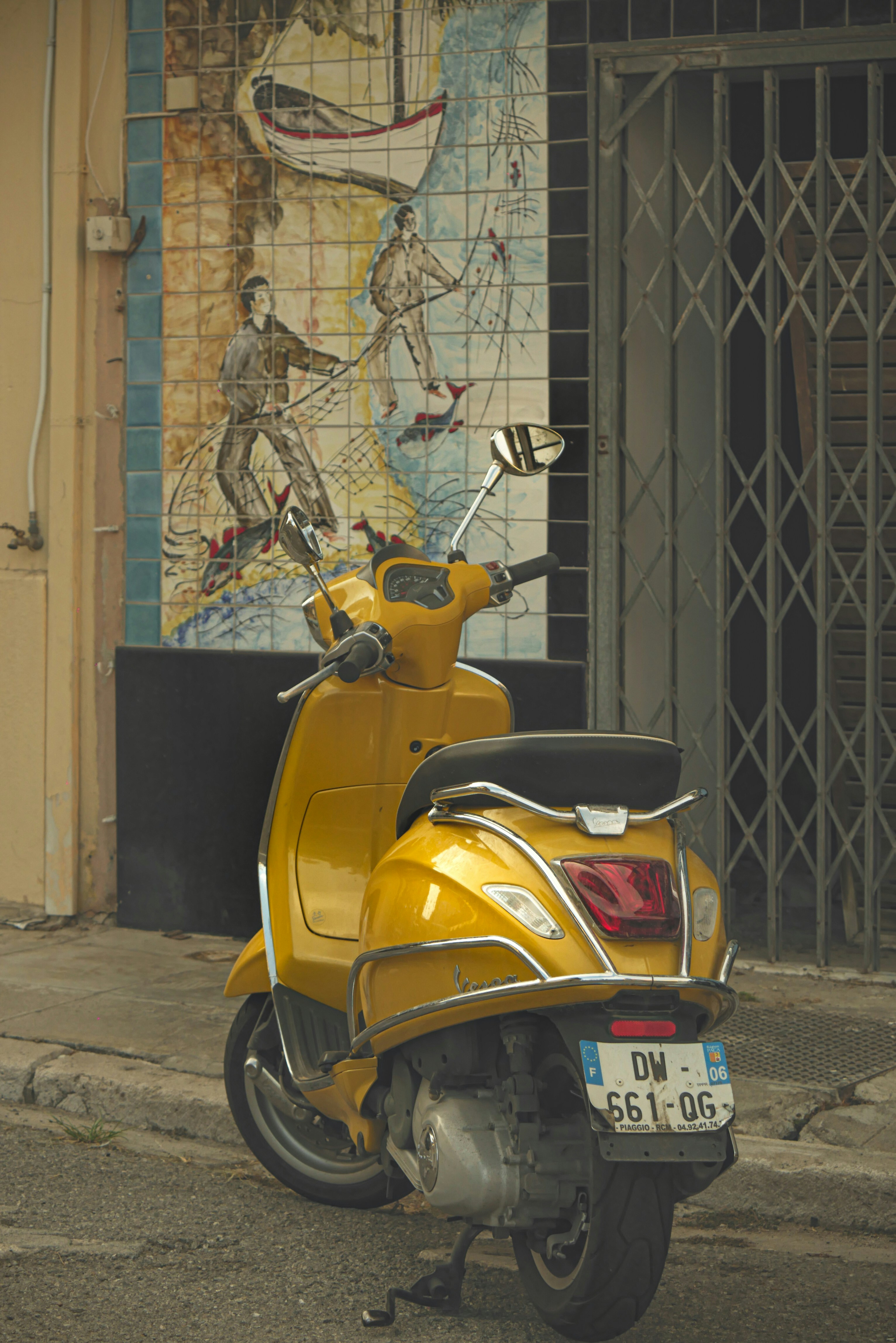 A yellow scooter parked on the side of the road