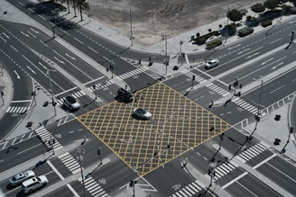 An aerial view of a city intersection with a yellow square