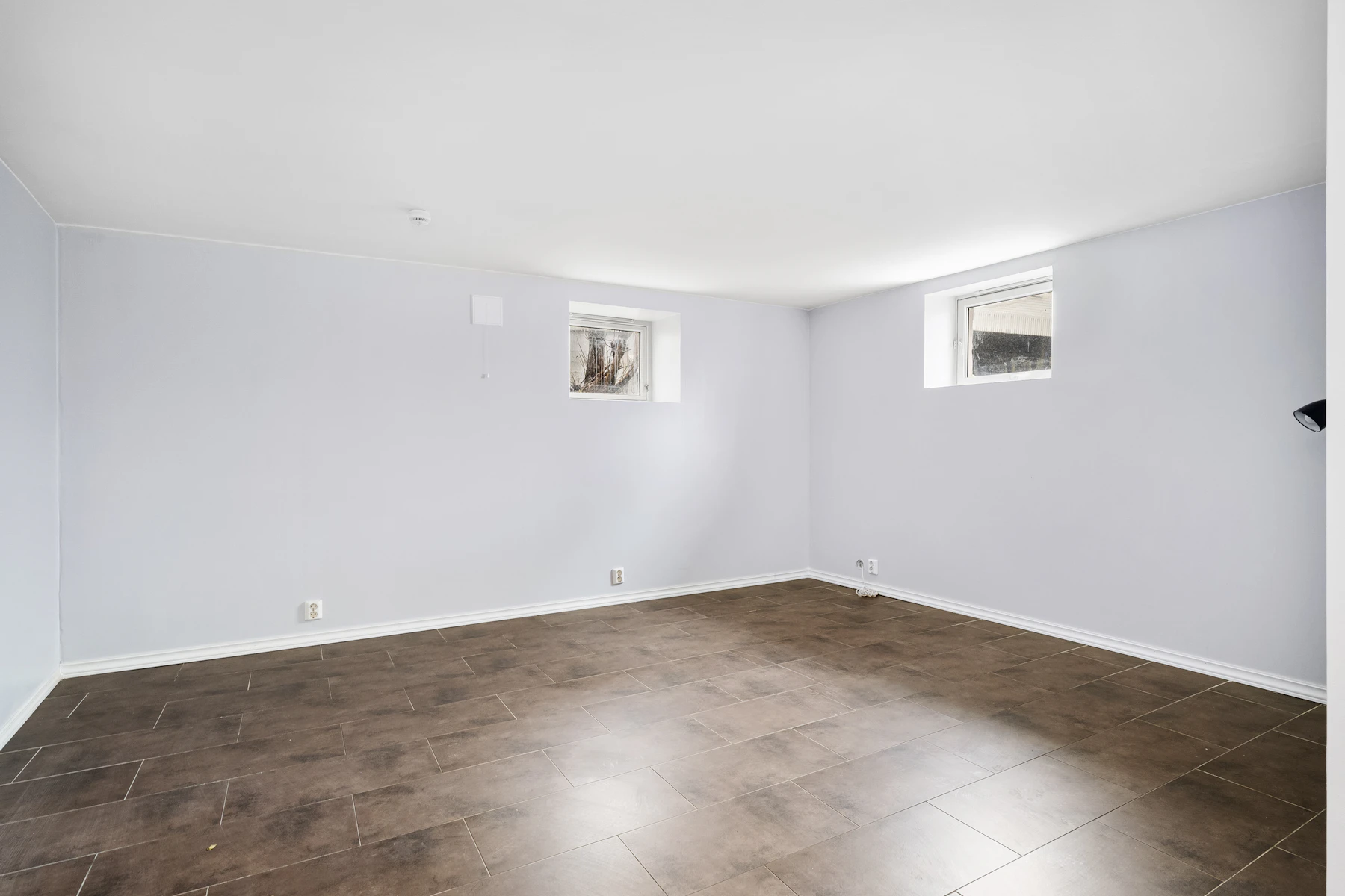 Empty room with finished hardwood flooring and white walls