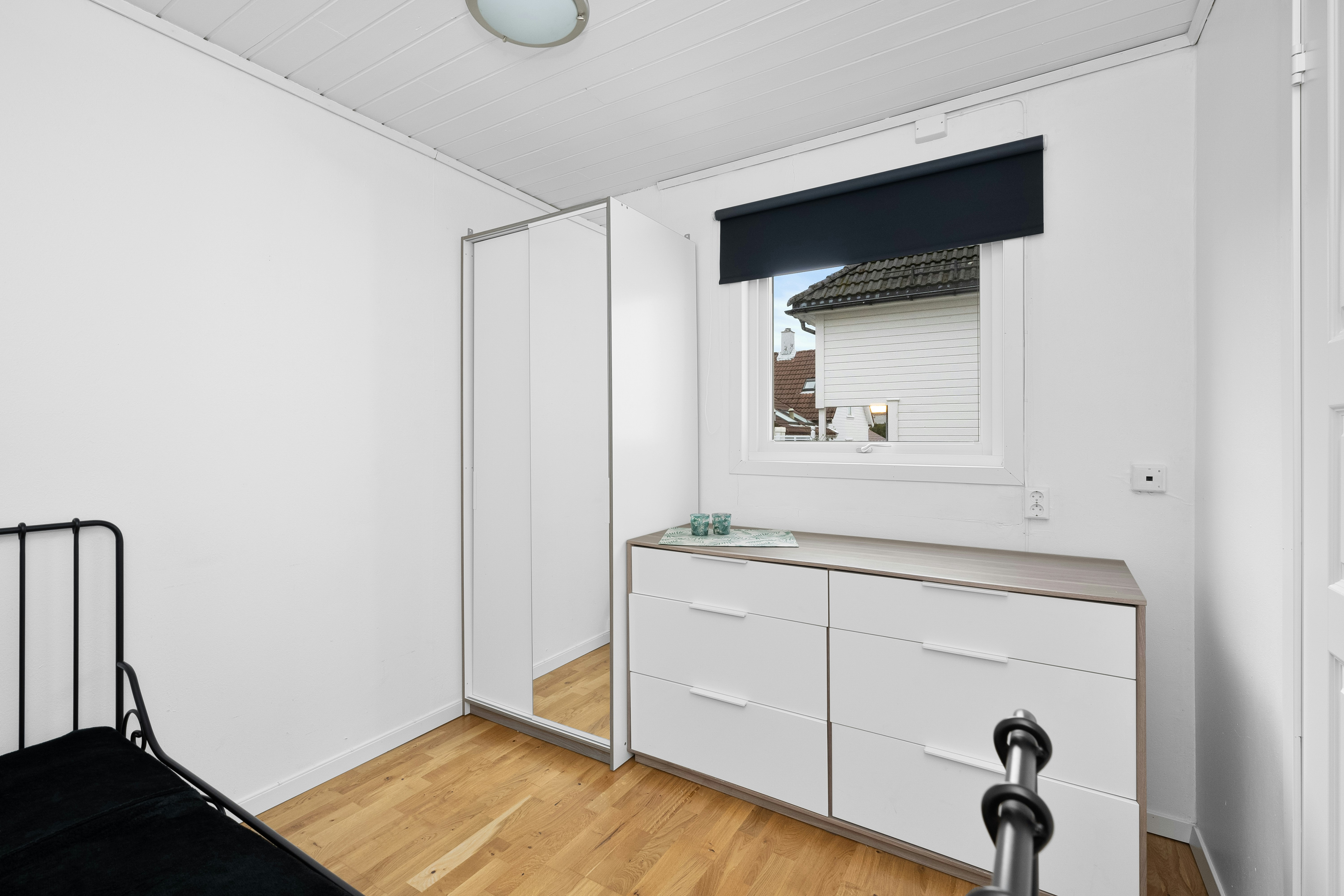 Minimalist bedroom after renovation with built-in wardrobe and smooth white walls