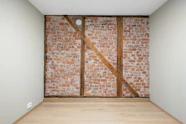 An empty room with a brick wall and wooden floor