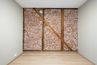 An empty room with a brick wall and wooden floor