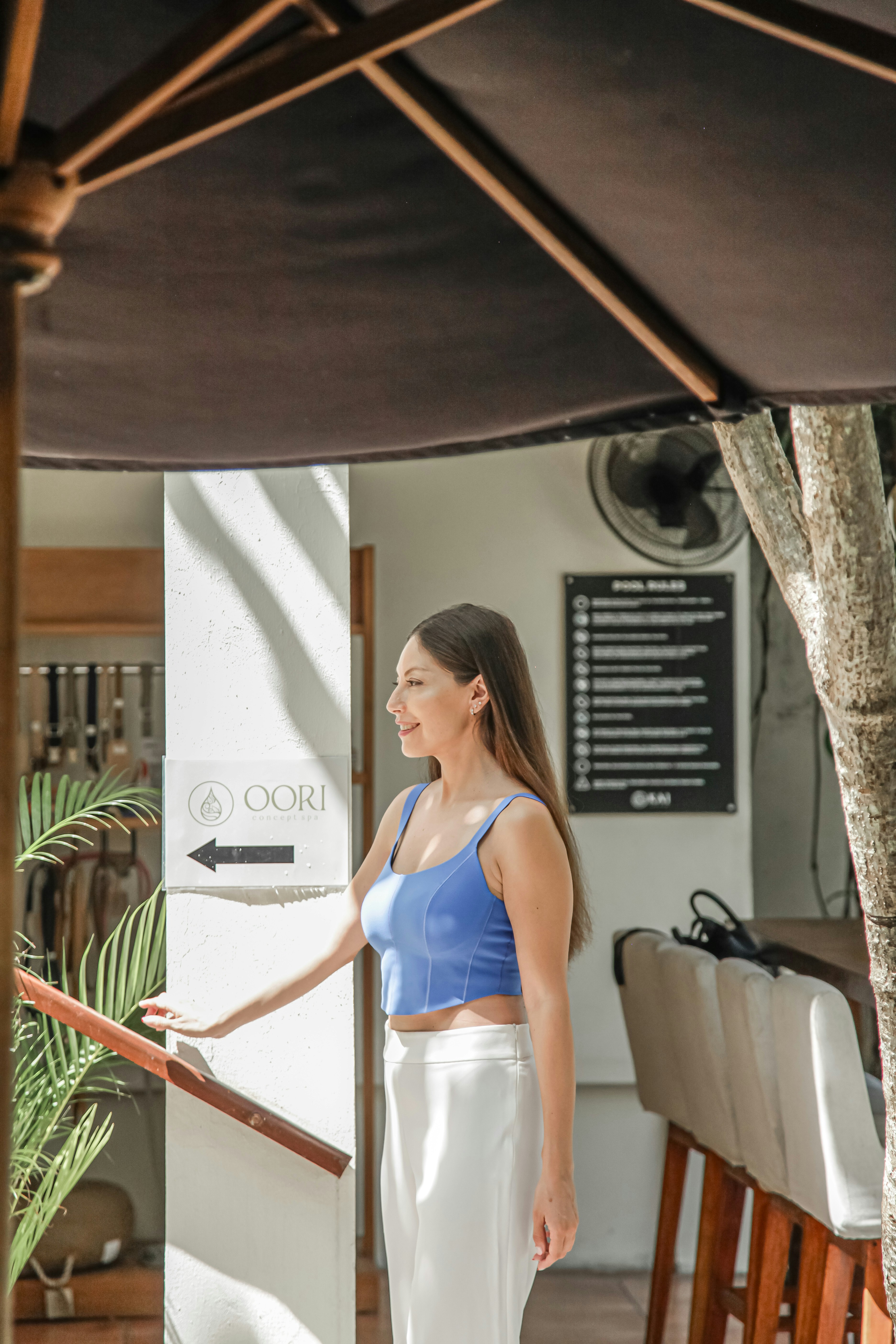A woman in a blue top and white pants