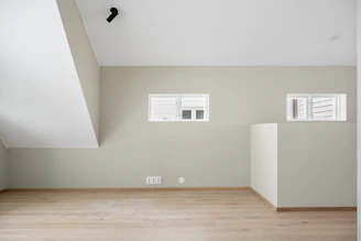 An empty room with white walls and wooden floors