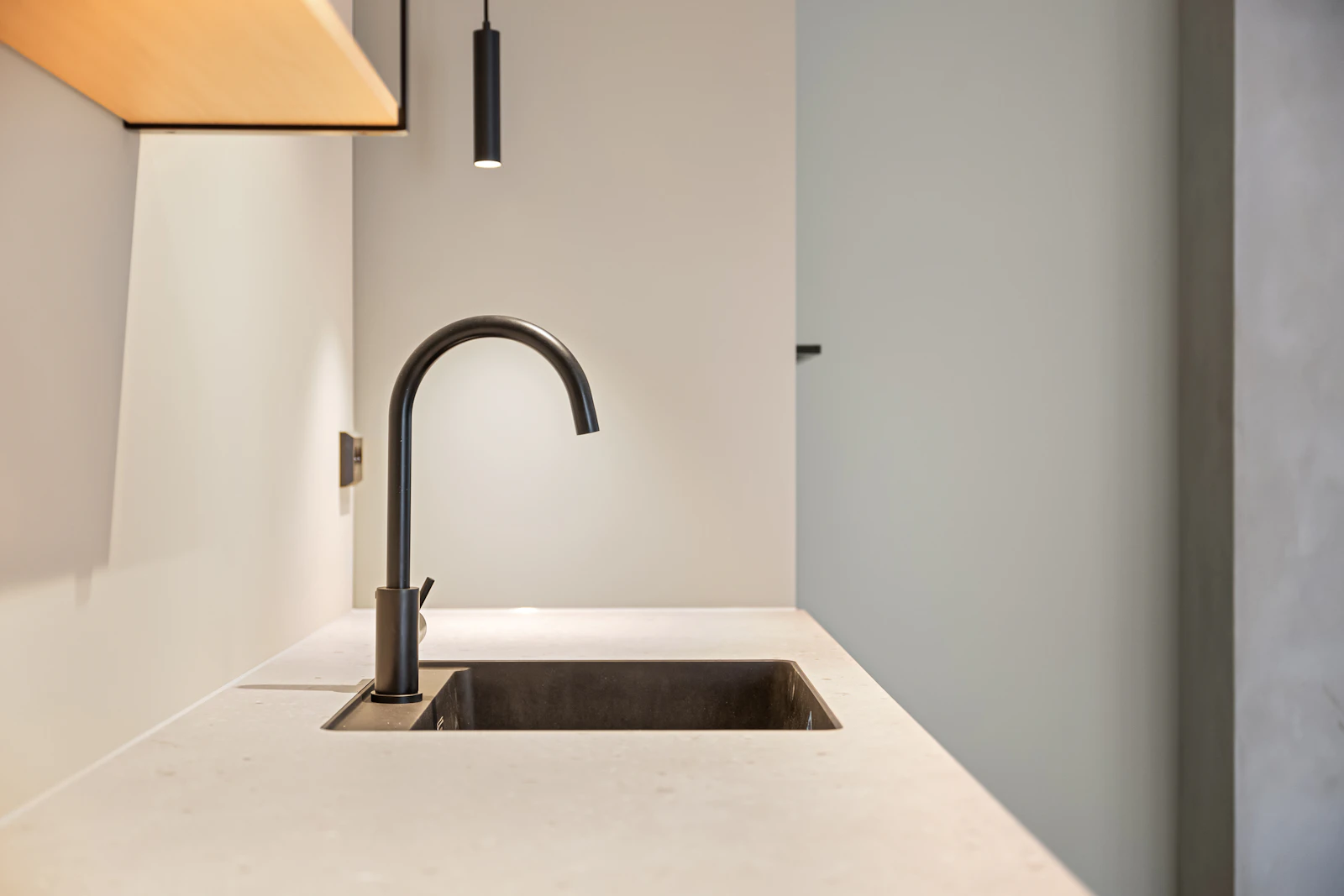 A modern kitchen sink and matte-black gooseneck faucet in a Saudi home, the kind of fixture that shows hard-water scale fastest