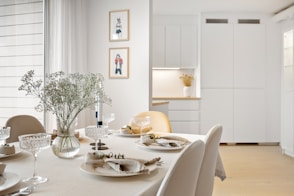 A dining room table with a vase of flowers on it