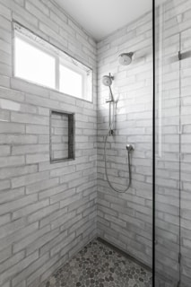 A walk in shower sitting next to a window