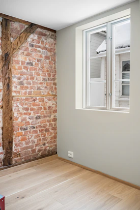 A room with a brick wall and a window