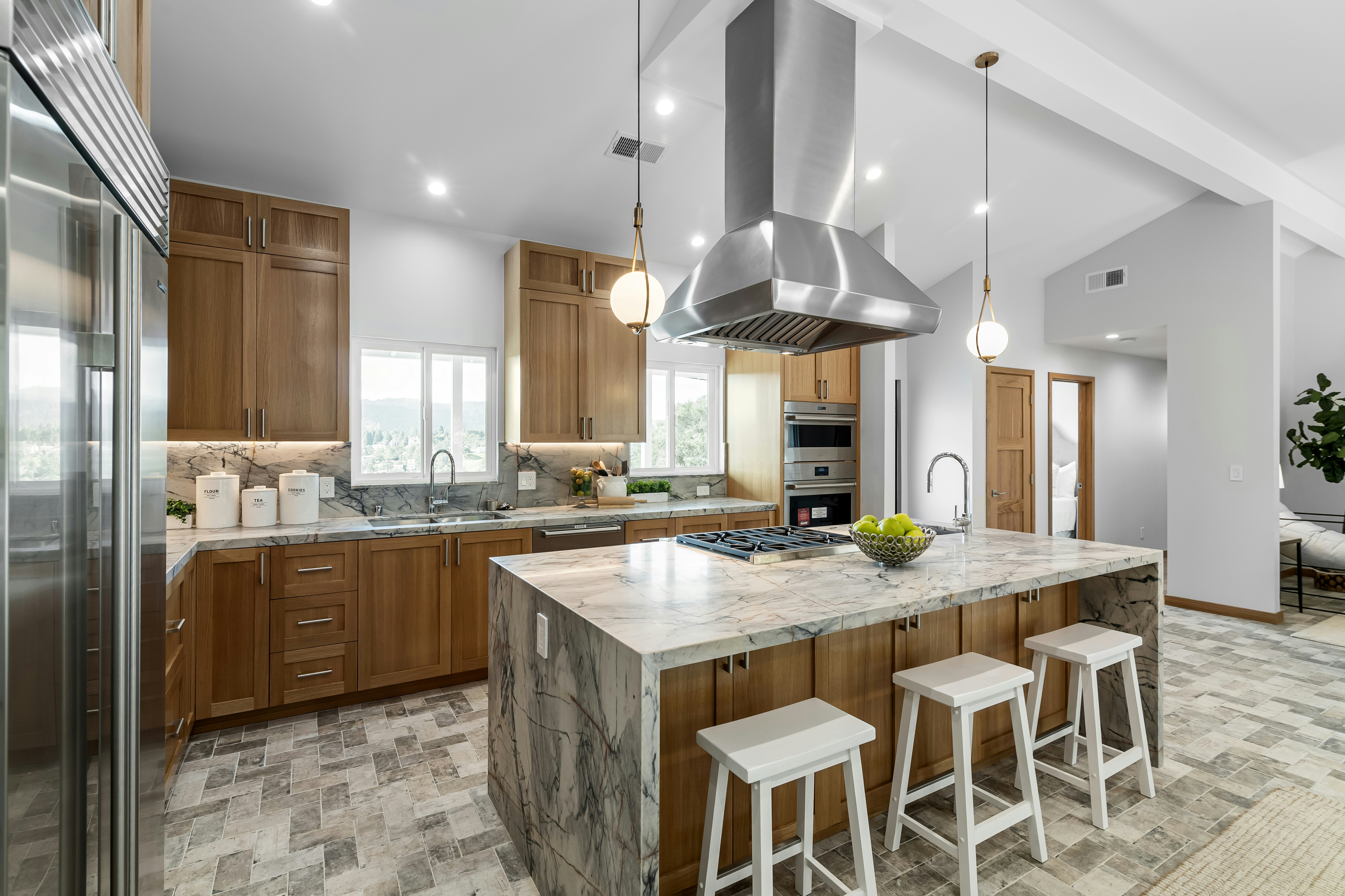 A sleek, modern kitchen with high-end finishes, stainless steel appliances, quartz countertops, and a large island, overlooking the Chicago River through floor-to-ceiling windows - high rise luxury