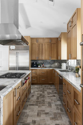 A kitchen with marble counter tops and wooden cabinets